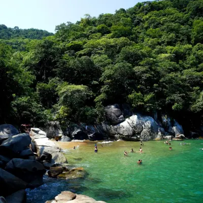 a group of people on a rock next to water