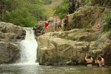 a group of people on a rock next to a river