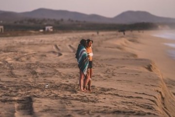 a person standing on top of a sandy beach