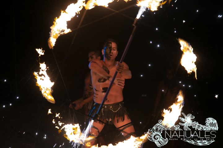 a man standing in front of a birthday cake with lit candles